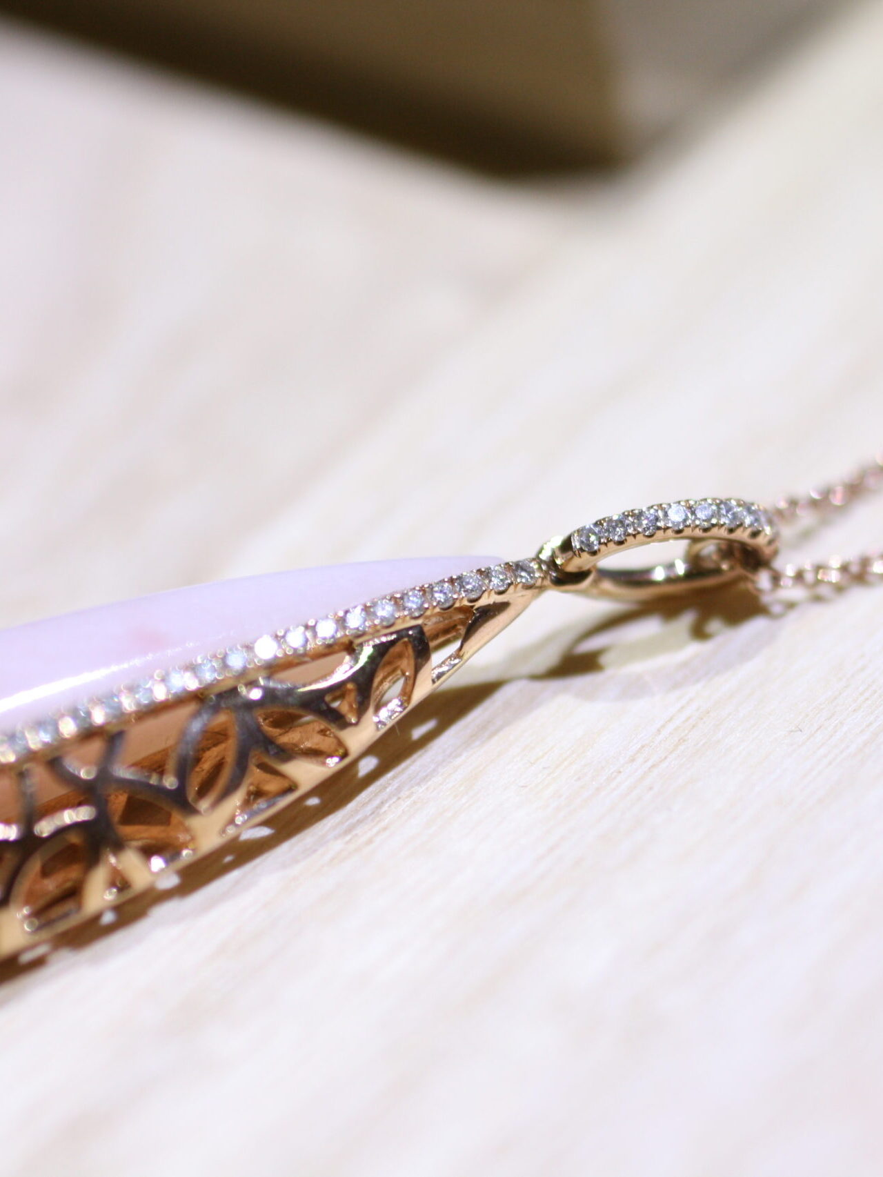 leaf motif rose gold with pink opal and diamond pendant from Bayside Collection by MIYOCO on the wooden table