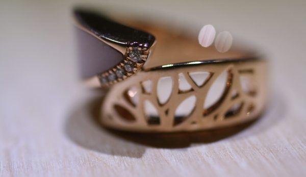 Details of leaf motif rose gold with pink opal and diamond ring from Bayside Collection by MIYOCO on the wooden table