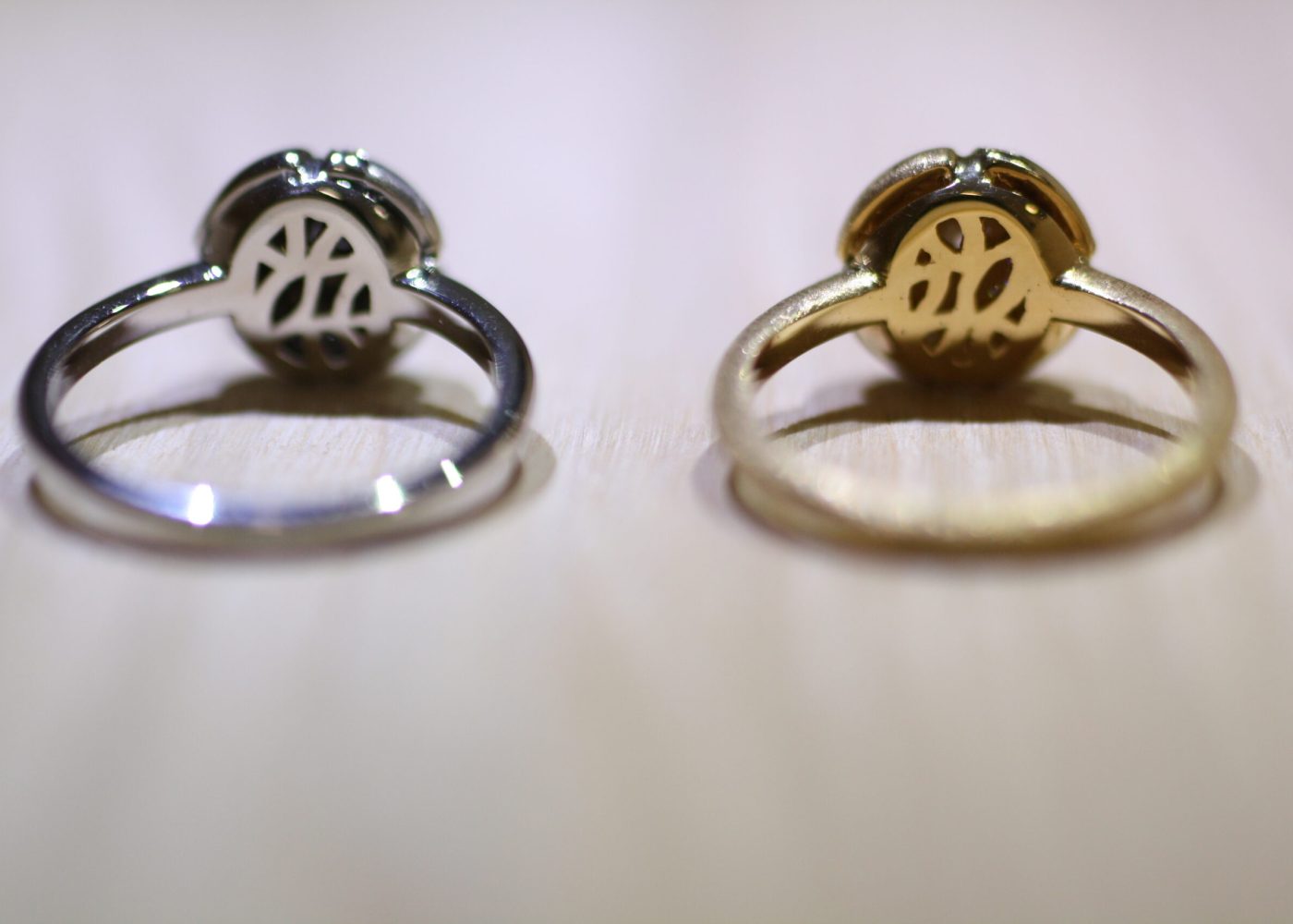 Lilac motif rings backside with leaf patterned openwork in yellow gold and white gold put on the wooden table